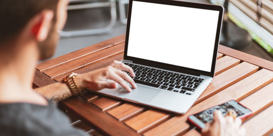 Ragazzo di spalle che lavora al laptop